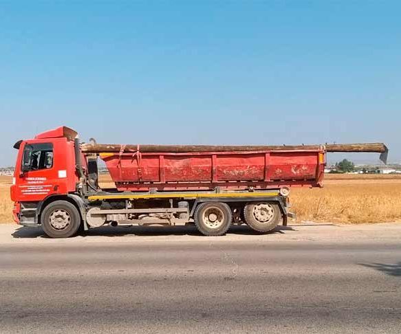 Un camión volquete rojo está estacionado al costado de la carretera.