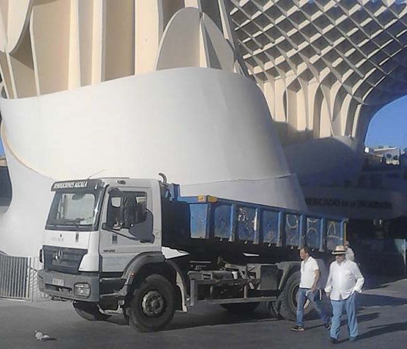 Un camión Mercedes está estacionado frente a un edificio.