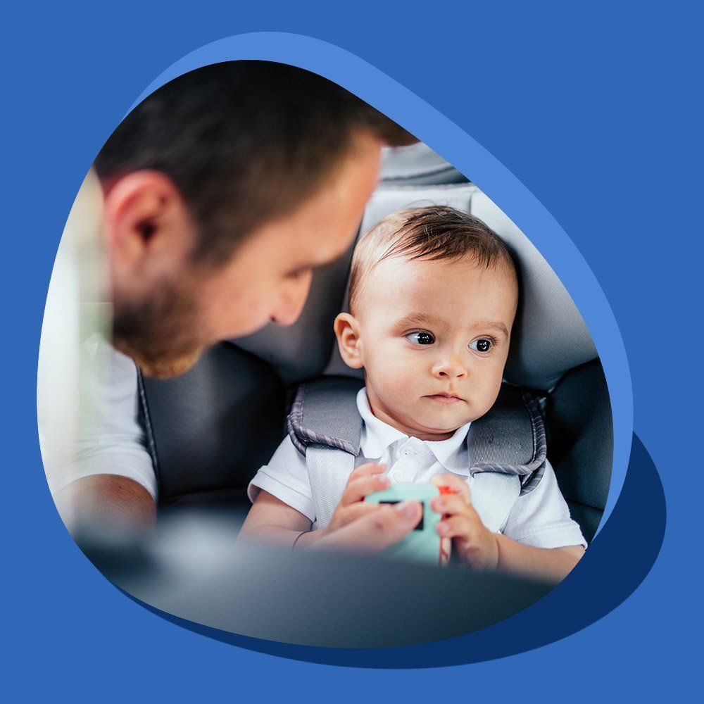 Un homme attache son enfant dans un siège auto
