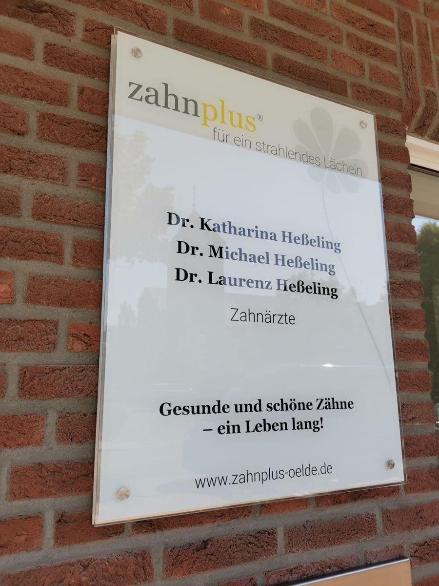Ein Schild an einer Backsteinmauer mit der Aufschrift „Zahnplus“