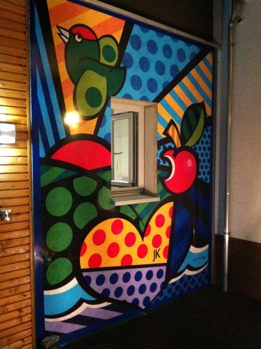 Ein farbenfrohes Gemälde an einer Wand mit einem Vogel und einem Apfel