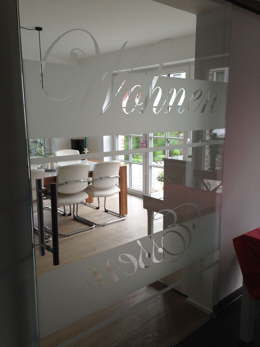 Ein Esszimmer mit einem Tisch und Stühlen hinter einer Glastür