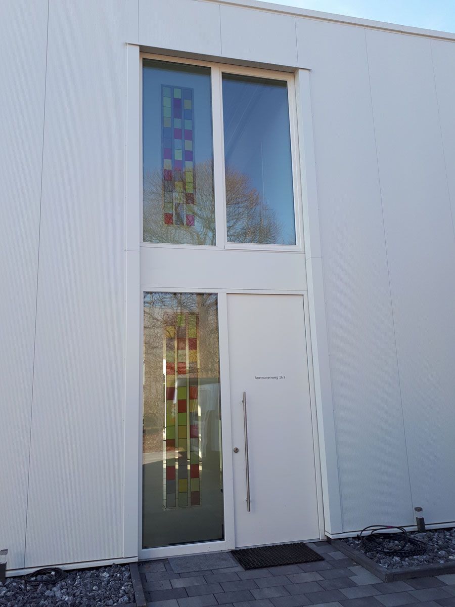 Ein weißes Gebäude mit einem großen Fenster und einer Tür