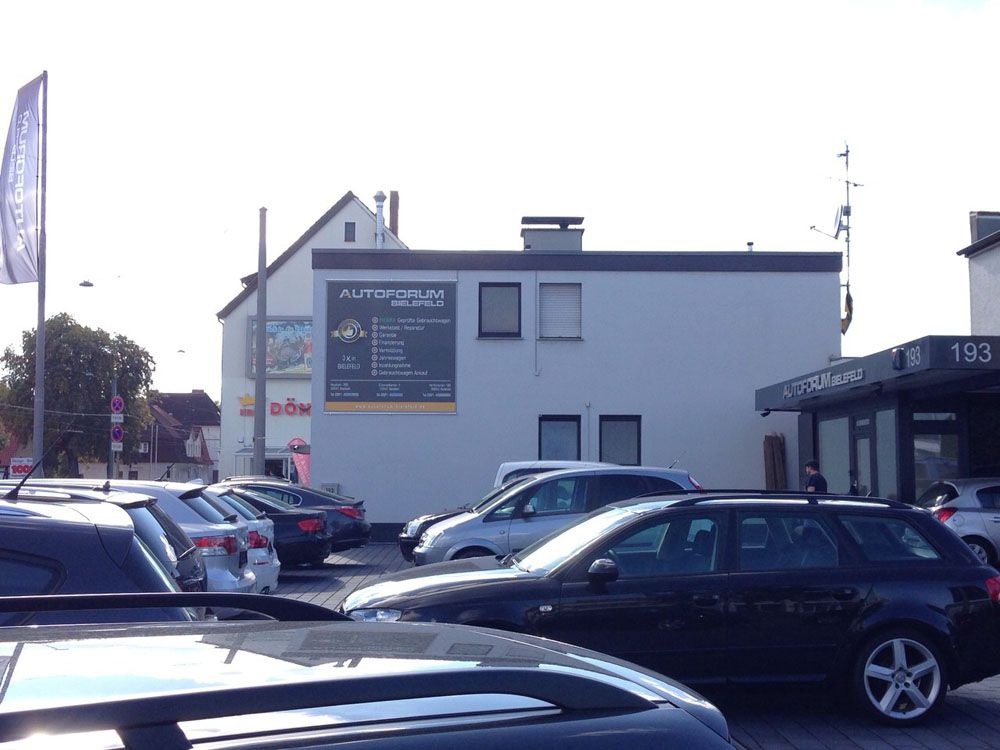 Viele Autos sind vor einem Gebäude geparkt