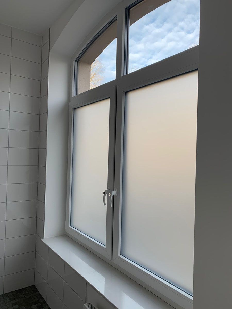 Ein Fenster mit weißem Rahmen und Milchglas