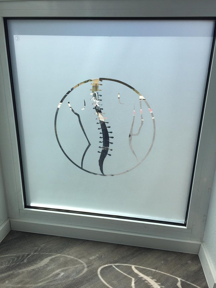 Ein Fenster mit der Zeichnung einer Wirbelsäule in einem Kreis darauf