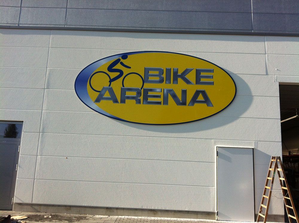 Ein gelbes Schild an der Seite eines Gebäudes mit der Aufschrift „Bike Arena“