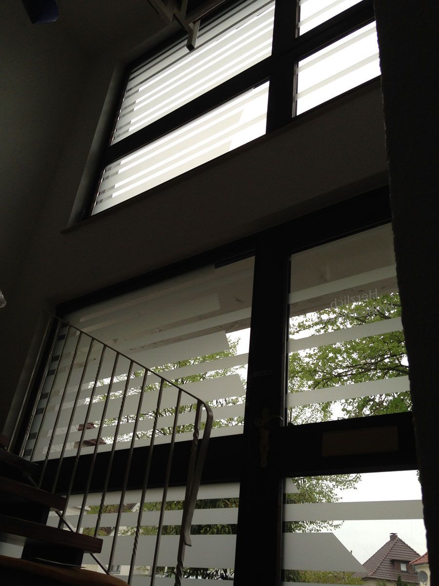 Blick nach oben auf ein Fenster mit einem Geländer und einer Treppe im Hintergrund