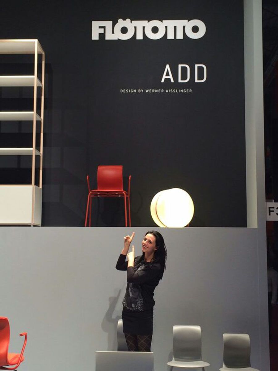 Eine Frau steht vor einem Schild mit der Aufschrift „Flototto add“