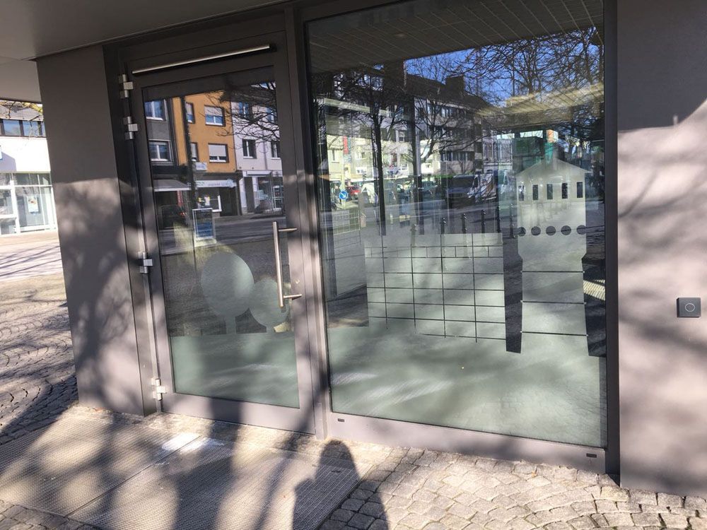 Eine Glastür mit der Spiegelung eines Gebäudes darin