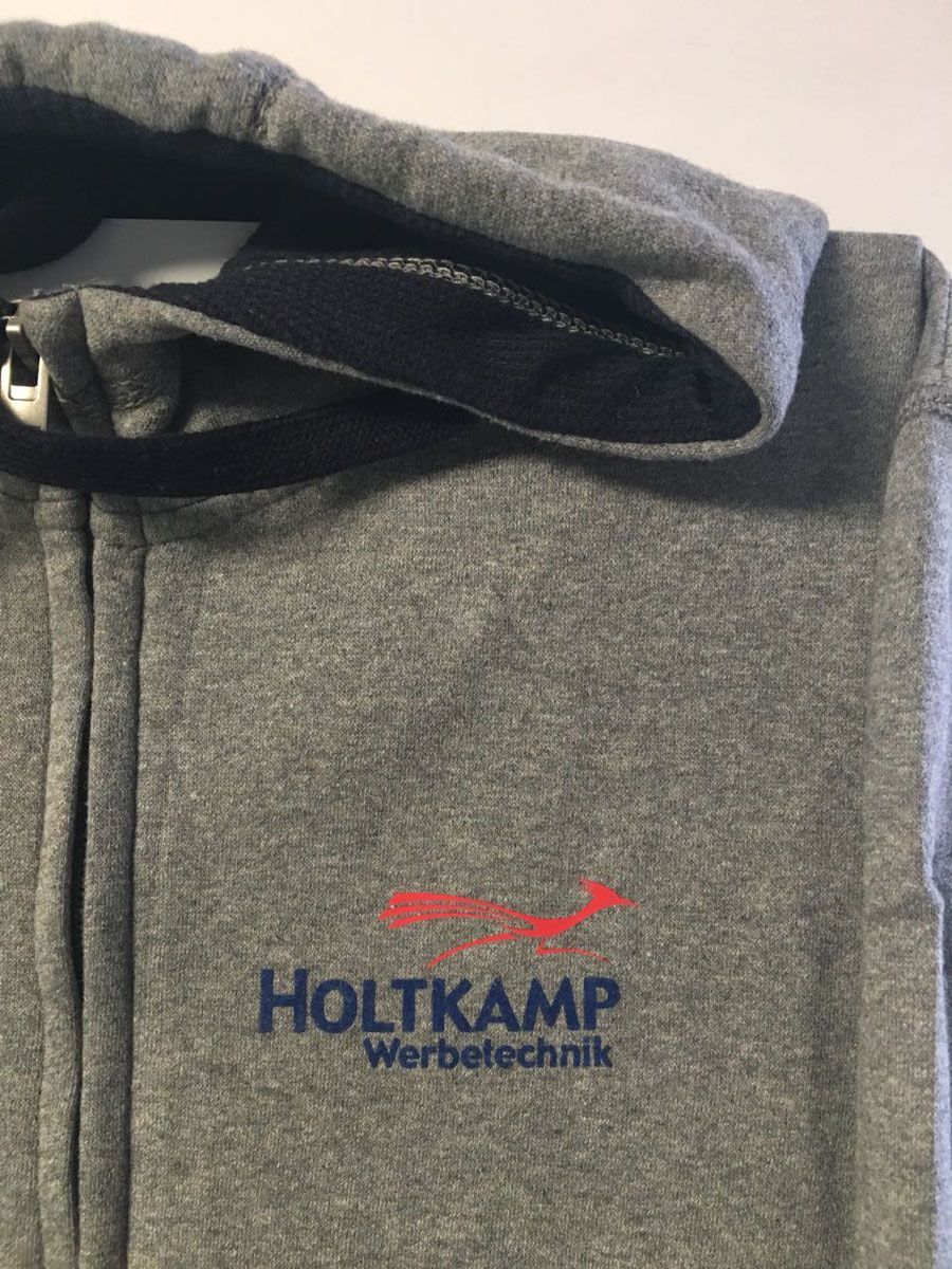 Ein grauer Hoodie mit dem aufgestickten Wort Holtkamp