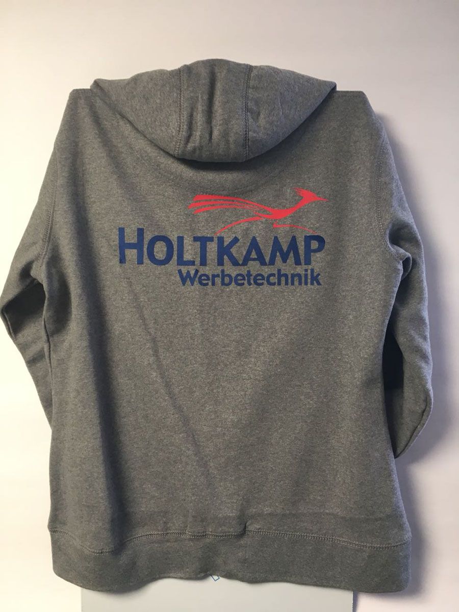 Auf der Rückseite eines grauen Hoodies steht Holtkamp Werbetechnik