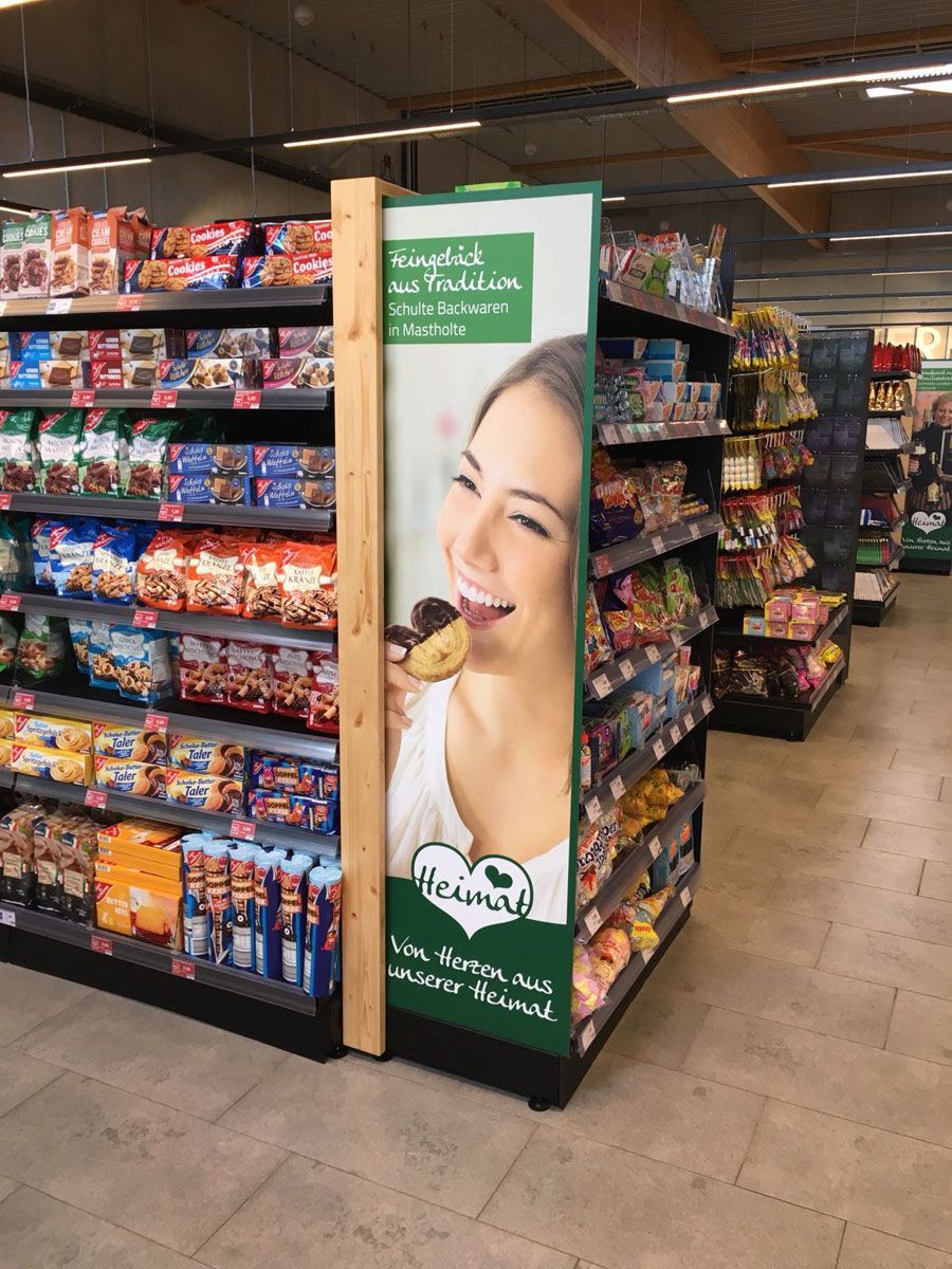 Eine Frau isst in einem Lebensmittelgeschäft einen Donut.