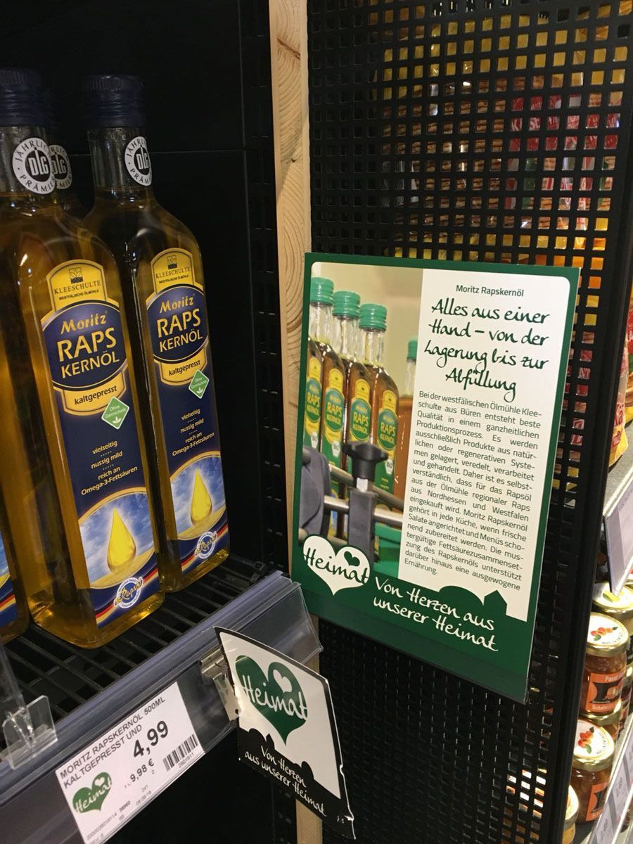 Eine Flasche Olivenöl steht auf einem Regal in einem Geschäft.