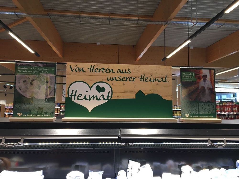 A sign hanging from the ceiling of a store says 