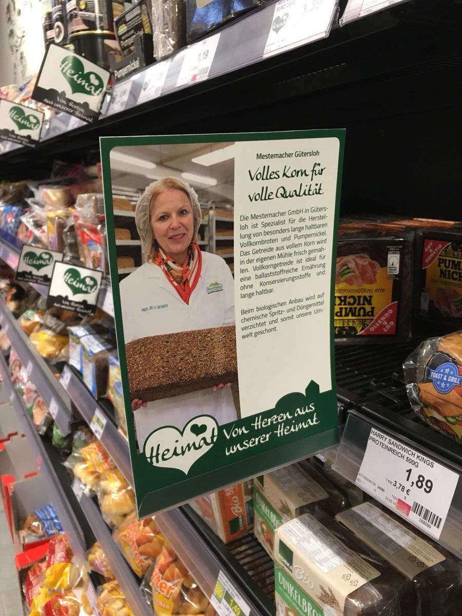 Eine Frau hält in einem Lebensmittelgeschäft einen Laib Brot.