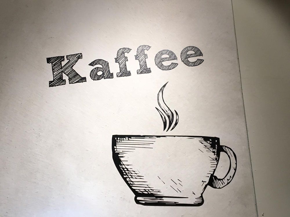 Eine Zeichnung einer Tasse Kaffee mit dem Wort „Kaffee“ darüber