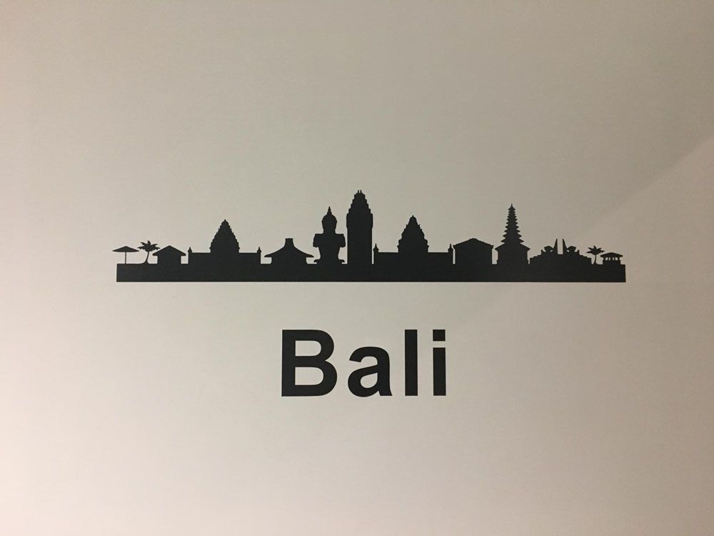 Eine weiße Wand mit einer Silhouette der Skyline von Bali