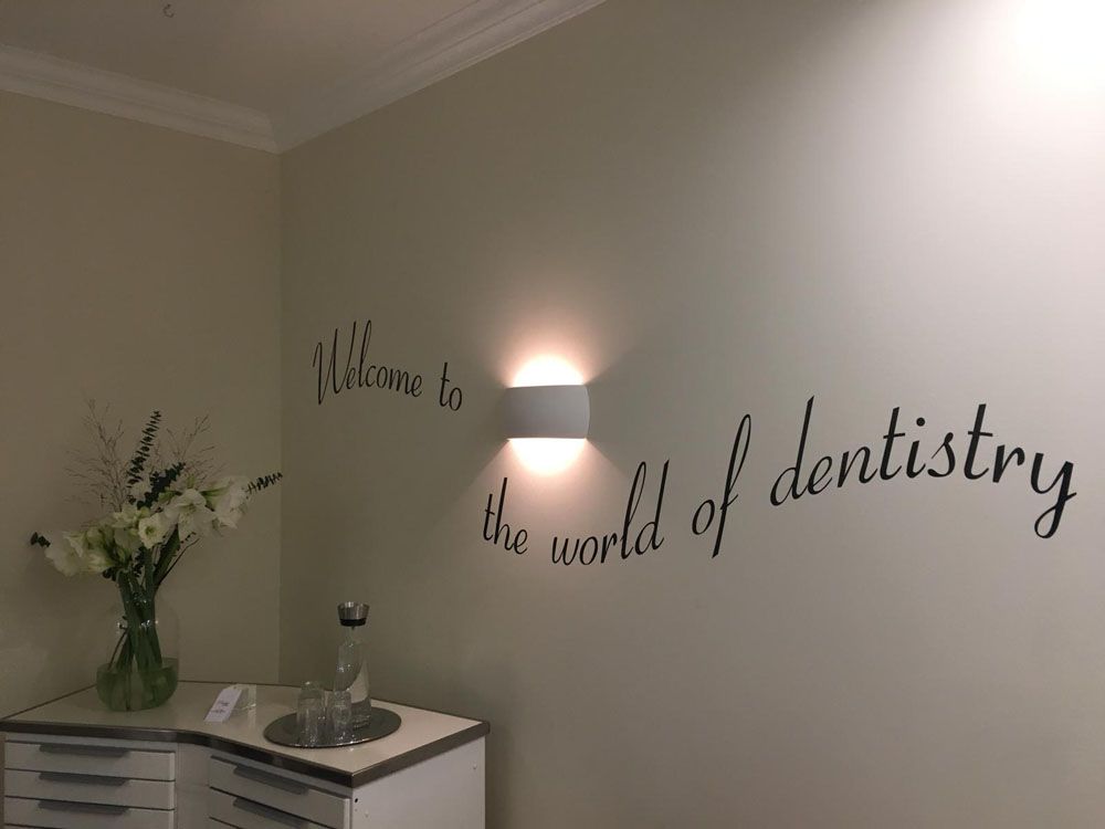 Eine Zahnarztpraxis mit einem Schild an der Wand mit der Aufschrift „Willkommen in der Welt der Zahnmedizin“.