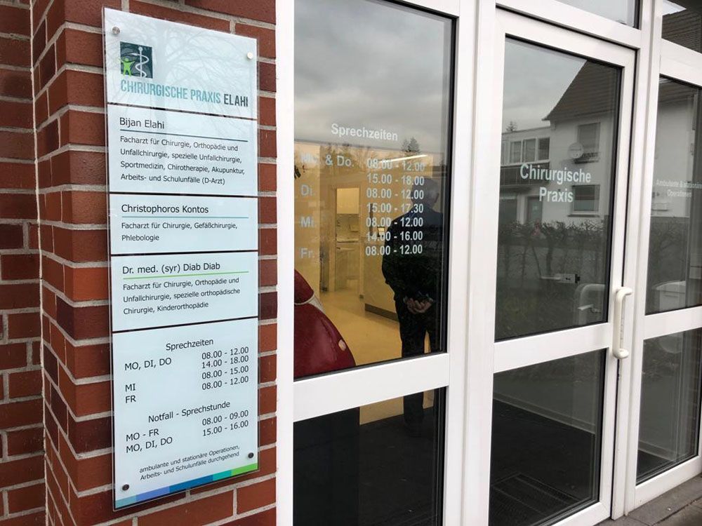 Ein Backsteingebäude mit einer Glastür und einem Schild an der Seite.