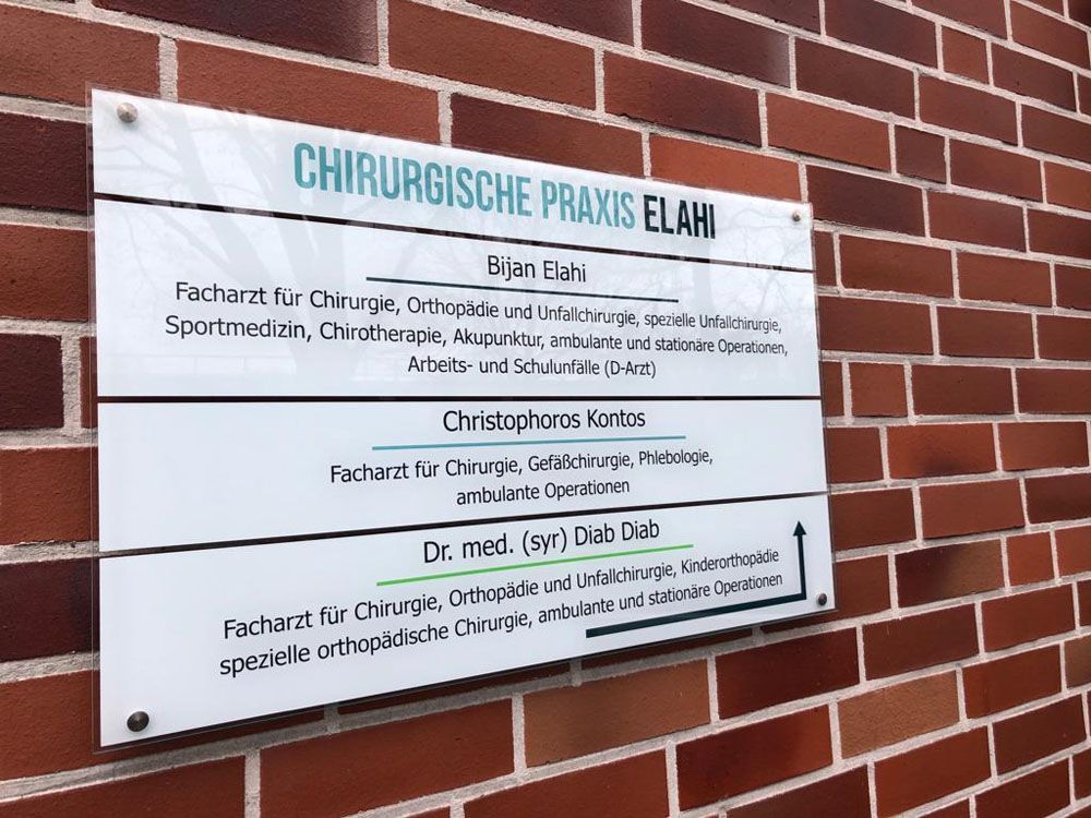 Ein Schild an einer Backsteinmauer sagt: Chirurgische Praxis Elahi