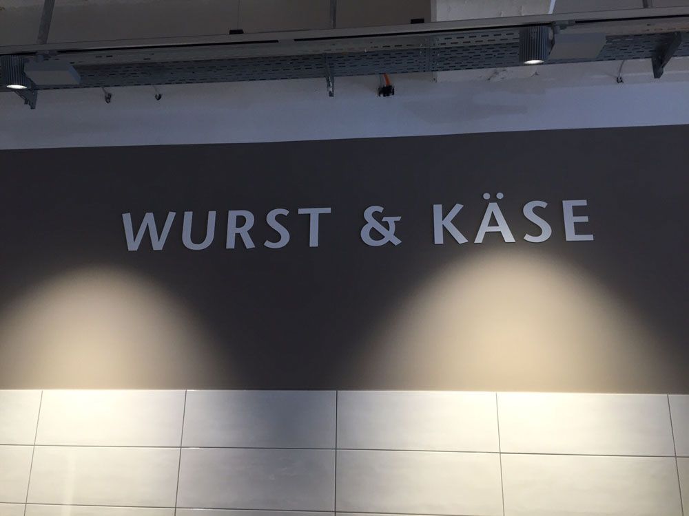 Ein Schild an einer Wand mit der Aufschrift „Wurst & Käse“