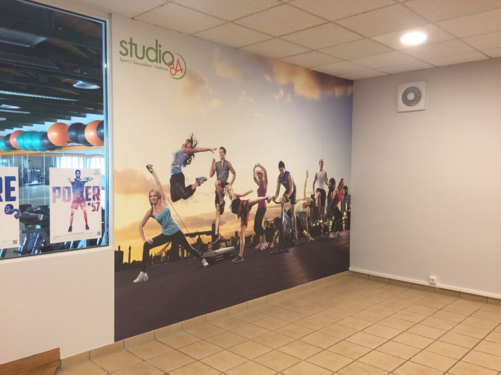 An der Wand einer Turnhalle hängt ein großes Wandgemälde.