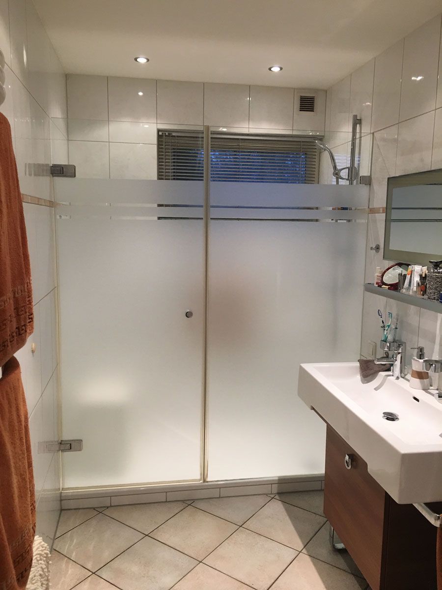 Ein Badezimmer mit Waschbecken und Duschkabine