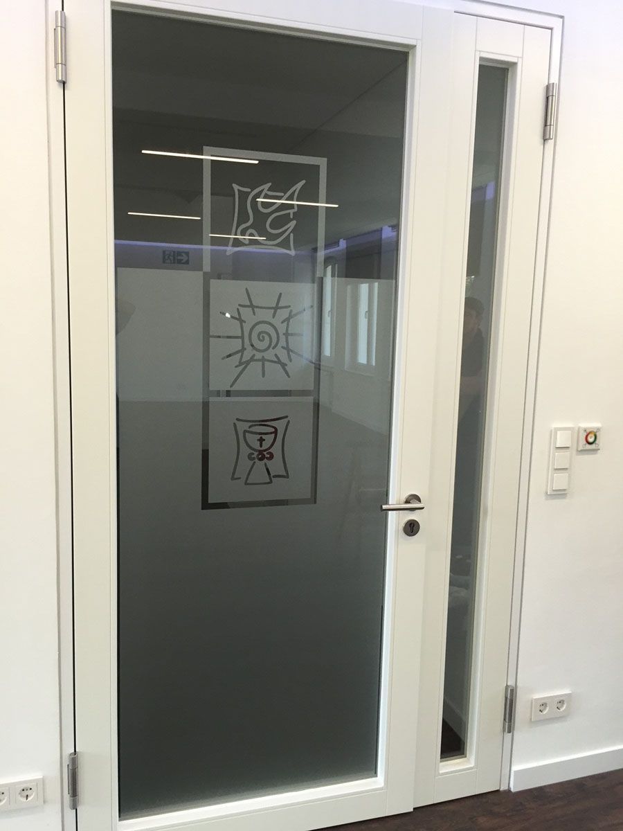 Eine weiße Tür mit einem Bild darauf in einem Zimmer.