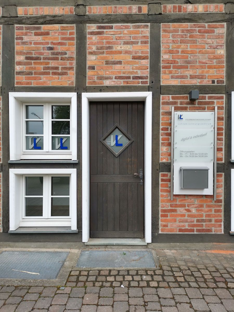 Ein Backsteingebäude mit einer Holztür und zwei Fenstern