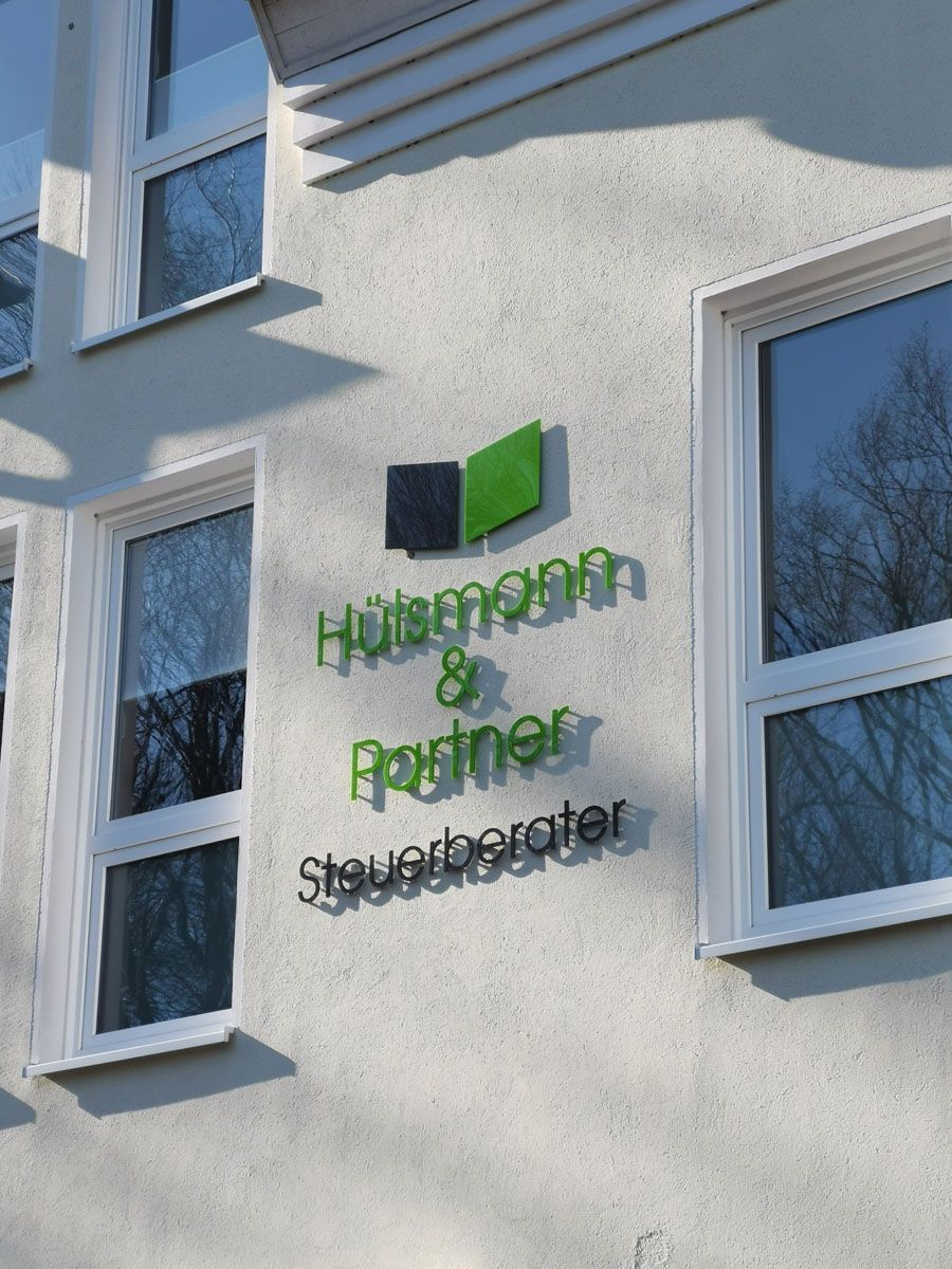 Ein Schild an der Seite eines Gebäudes sagt Holzmann & Partner