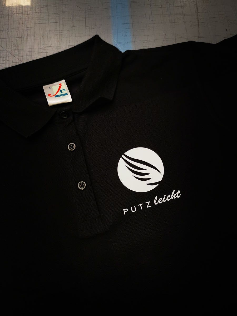 Ein schwarzes Poloshirt mit dem aufgestickten Wort Putz