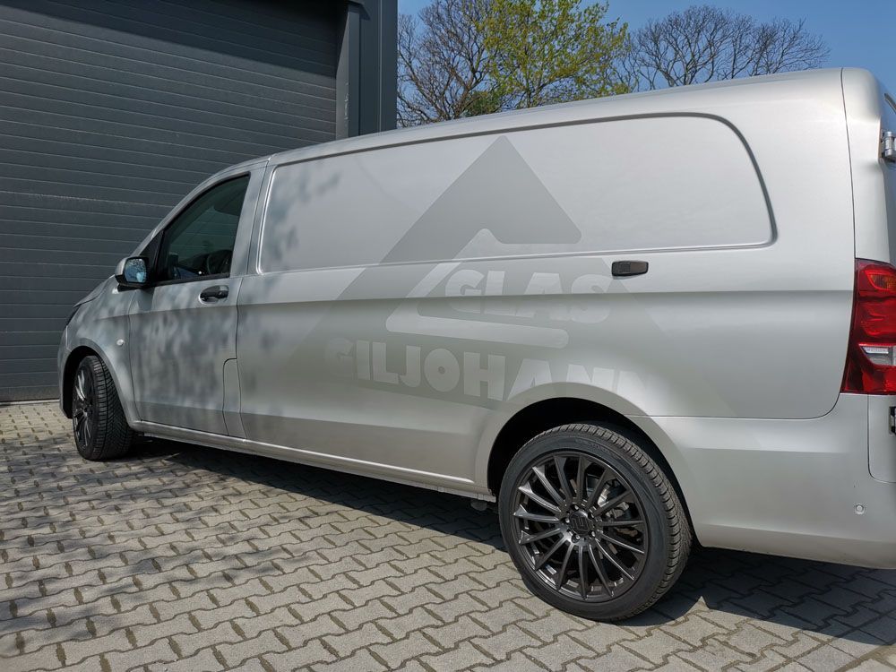 Ein silberner Lieferwagen steht auf einer gepflasterten Auffahrt