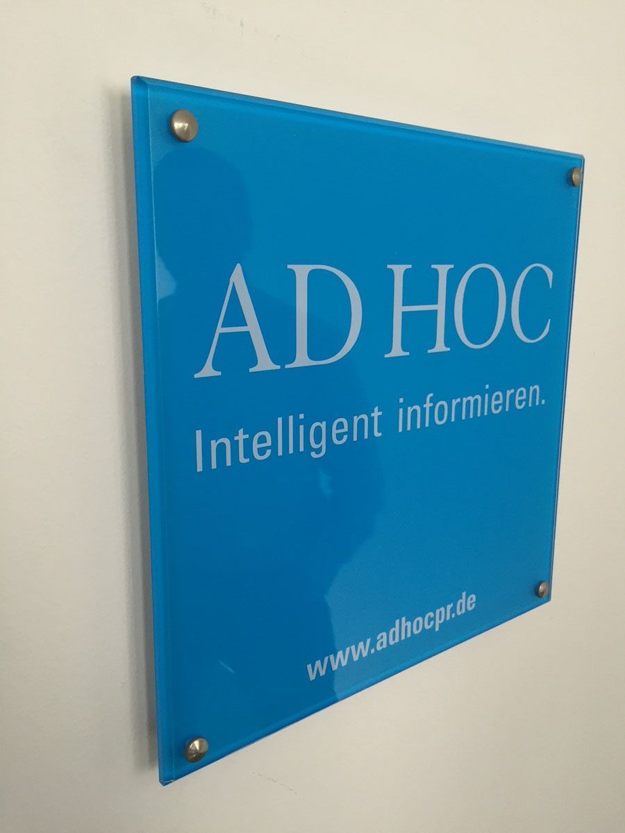 Ein blaues Schild mit der Aufschrift „ad hoc intelligent informieren“