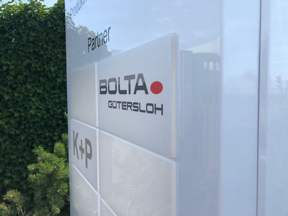 Ein weißes Gebäude mit einem Schild mit der Aufschrift „Bolta Guterloh“ darauf.
