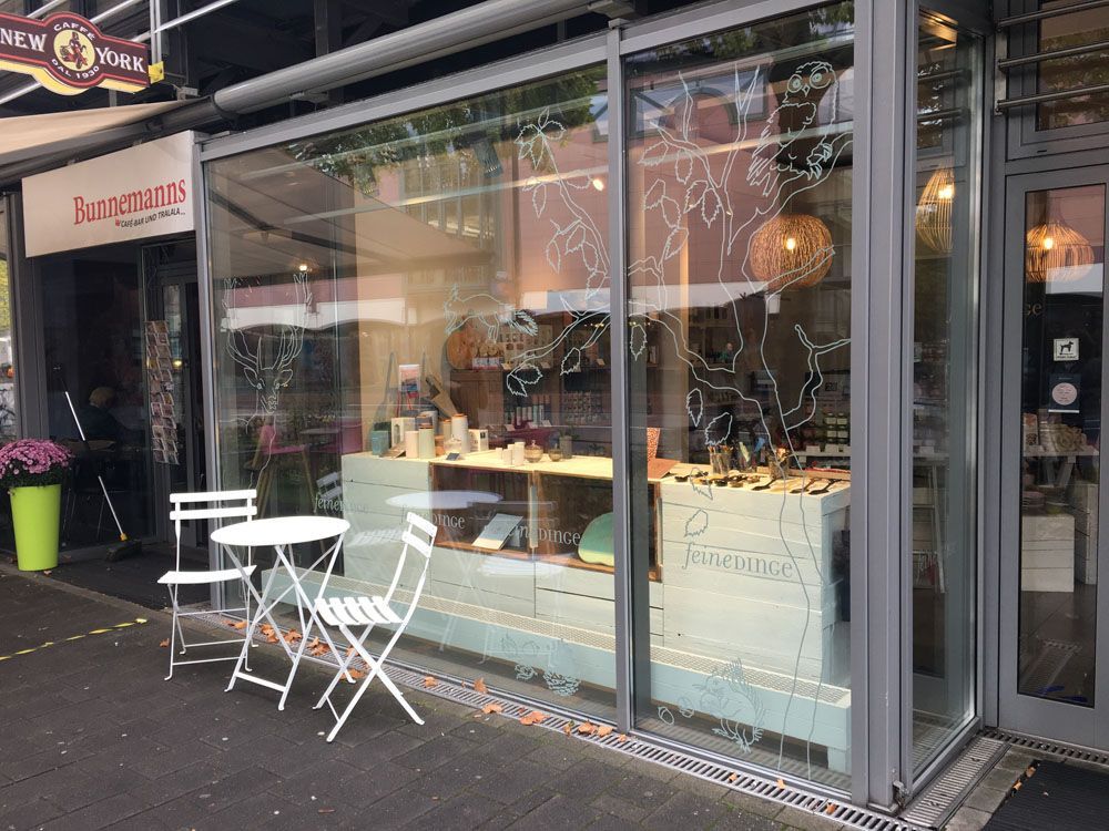 Eine Ladenfront mit einem Tisch und Stühlen davor.