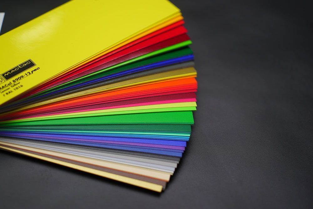 Ein Stapel verschiedenfarbiger Blätter Papier auf einem Tisch