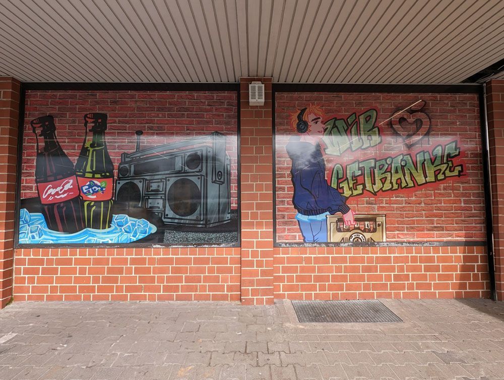 Eine Ziegelwand mit einer Coca-Cola- und Fanta-Werbung darauf