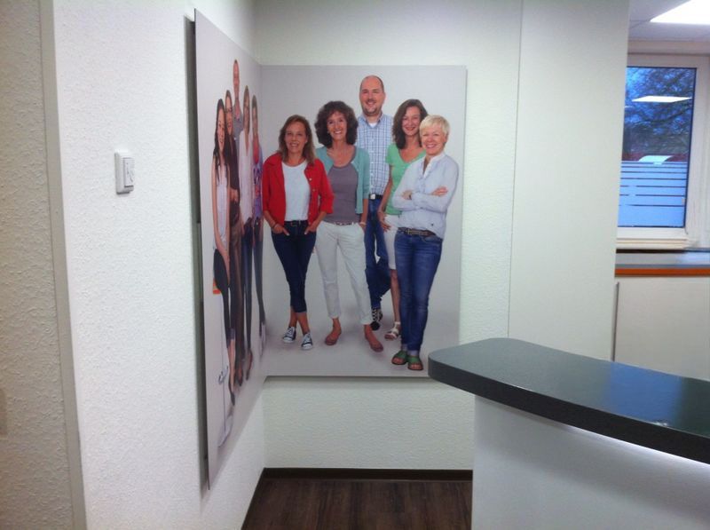 Eine Gruppe von Menschen, die nebeneinander auf einer Mauer stehen