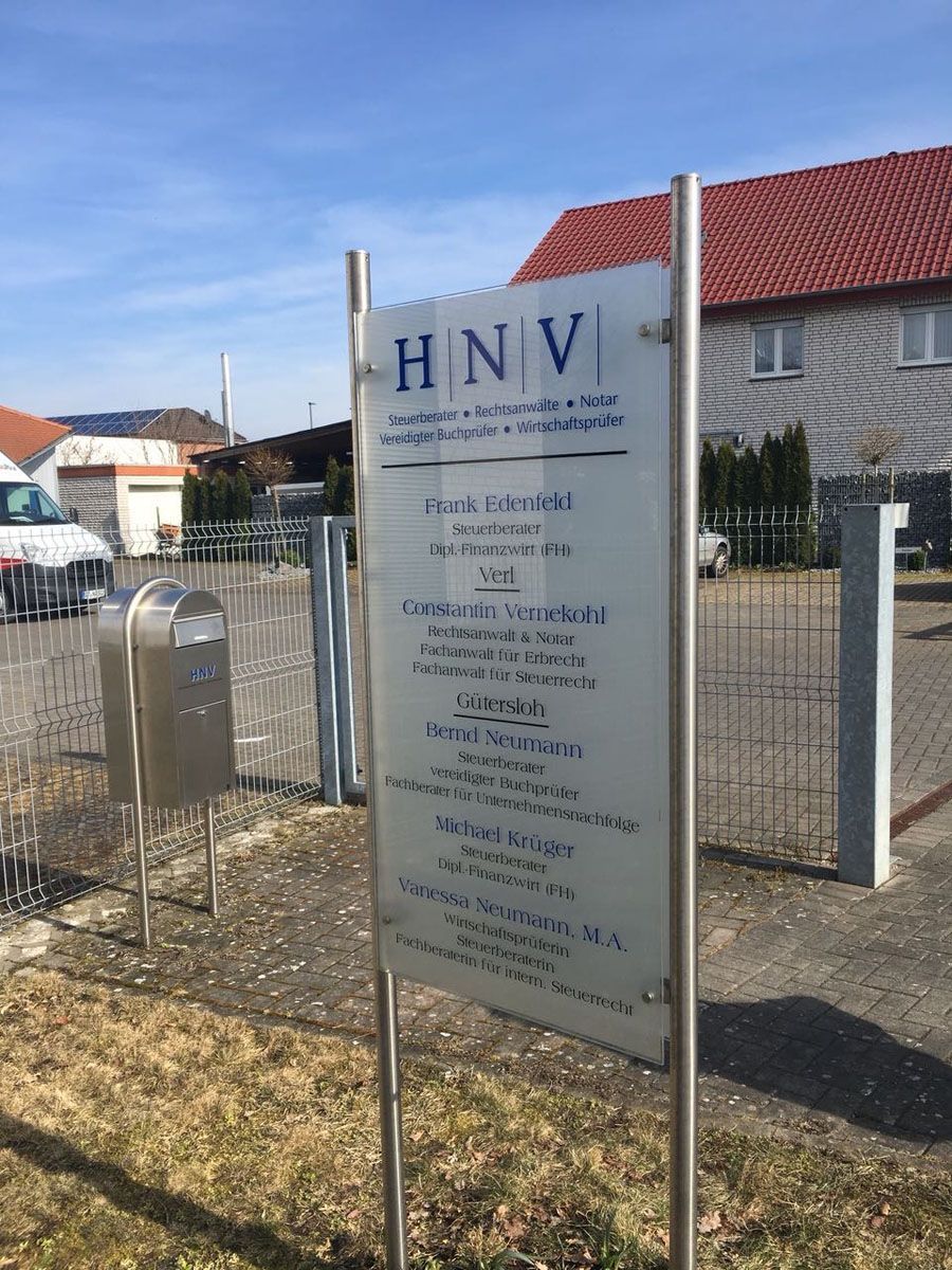Vor einem Gebäude steht ein Schild mit der Aufschrift „HNV“.