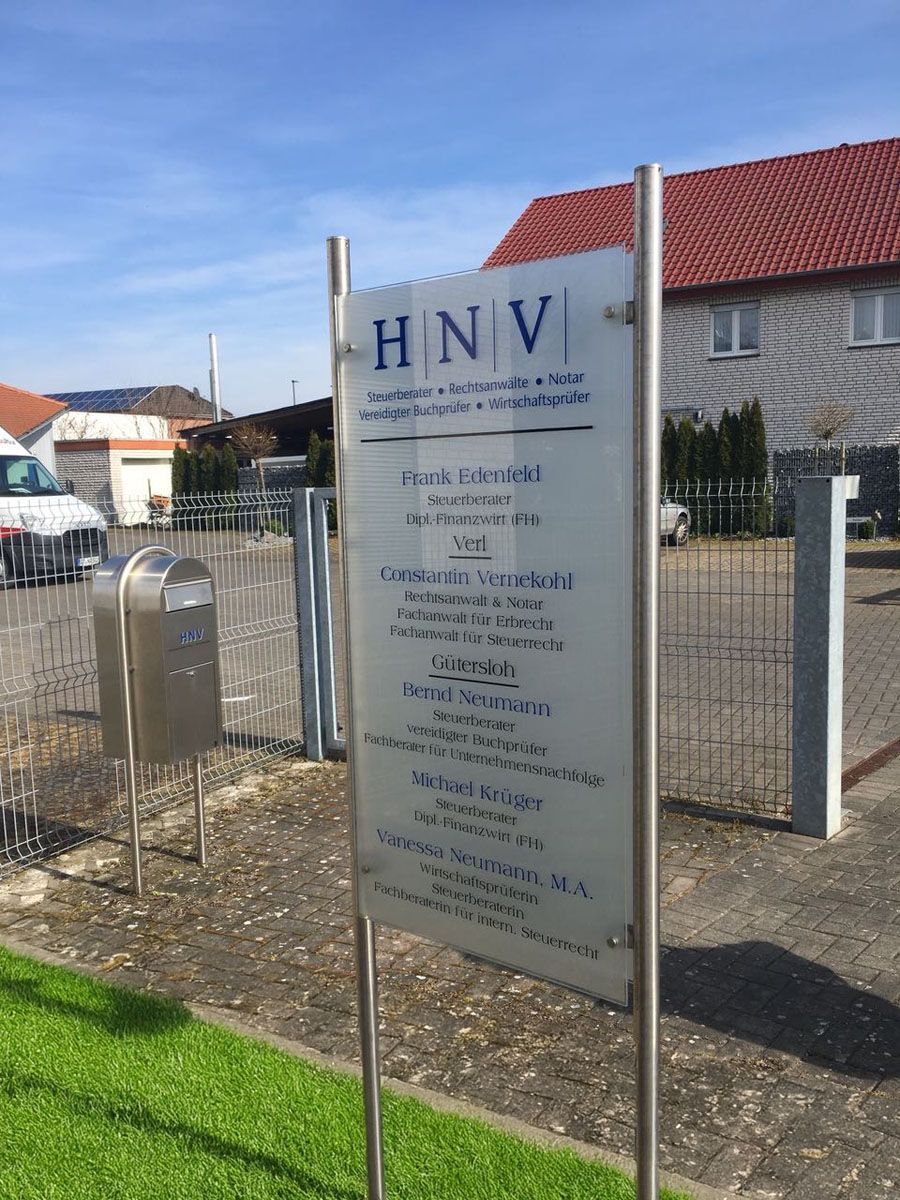 Vor einem Zaun sitzt ein Schild mit der Aufschrift „HNV“.
