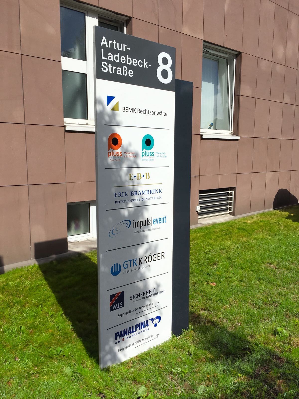 Vor einem Gebäude steht ein großes Schild mit der Zahl 8.