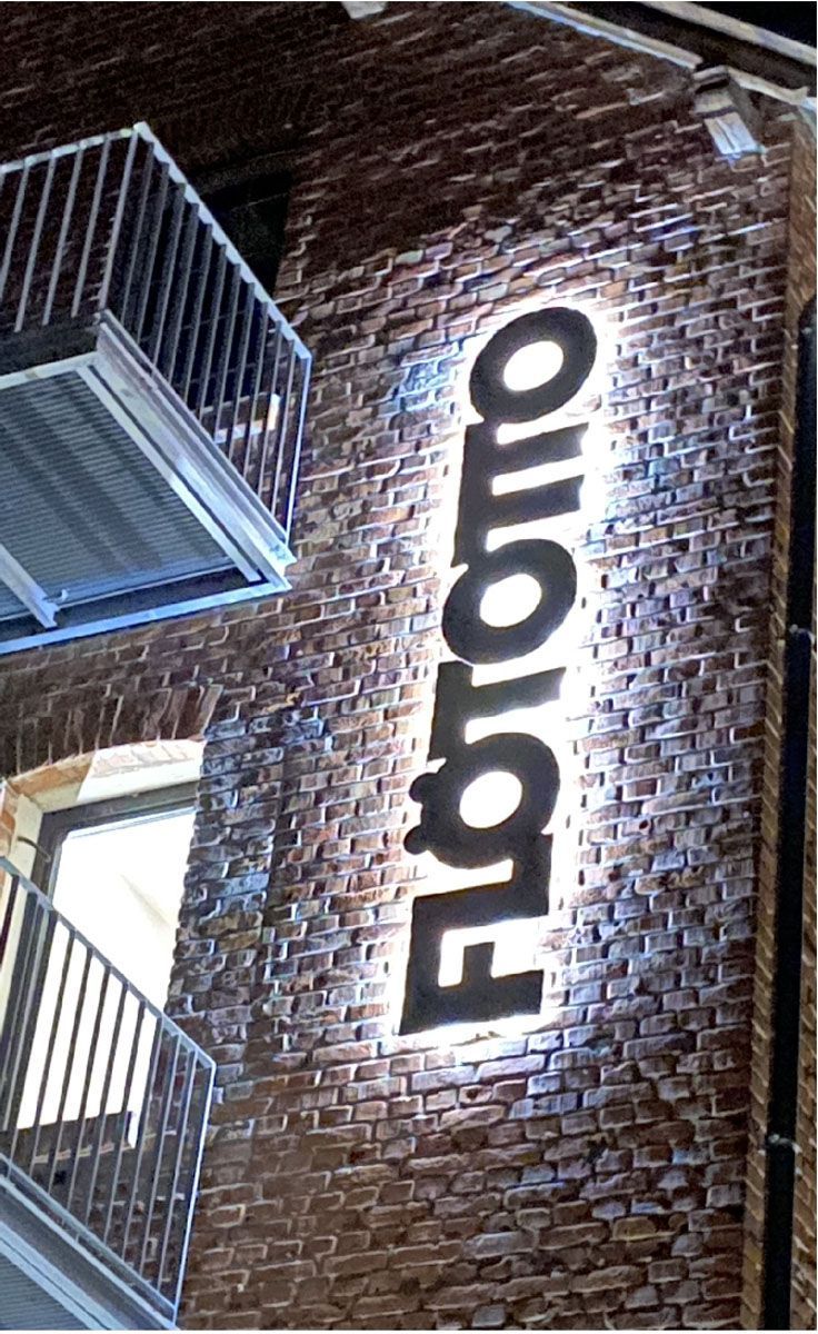 Eine Backsteinmauer mit einem Schild mit der Aufschrift „Fibromo“ darauf