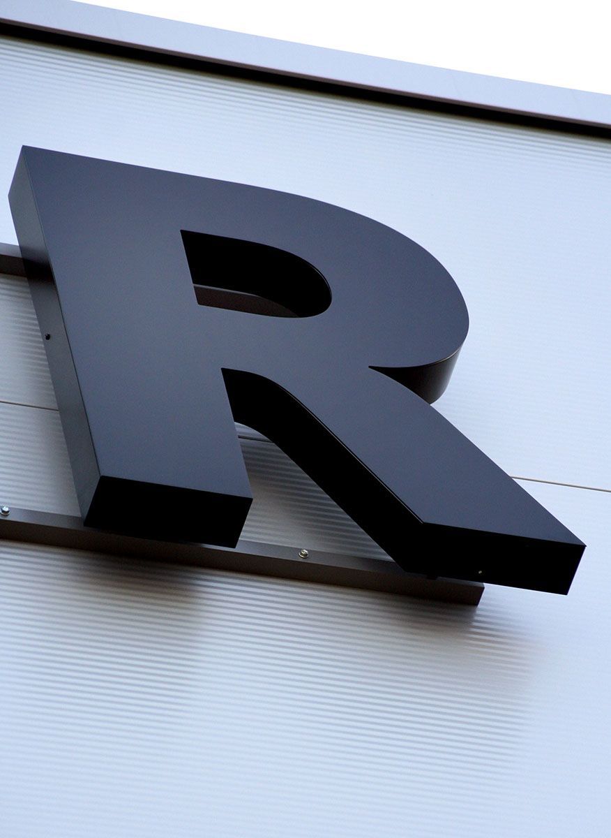 Ein großer schwarzer Buchstabe R steht an der Seite eines Gebäudes