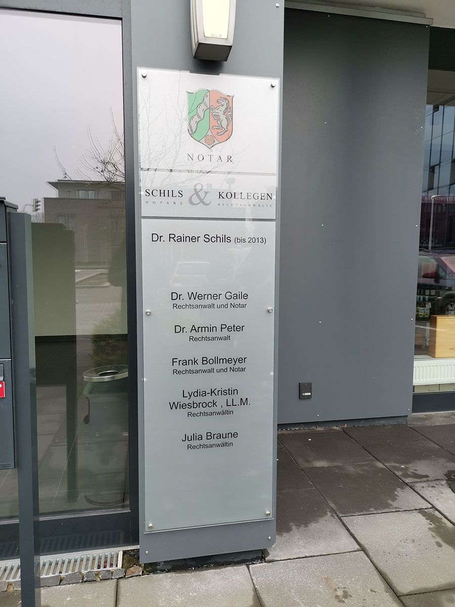 Ein Schild an der Seite eines Gebäudes mit einem Wappen darauf.