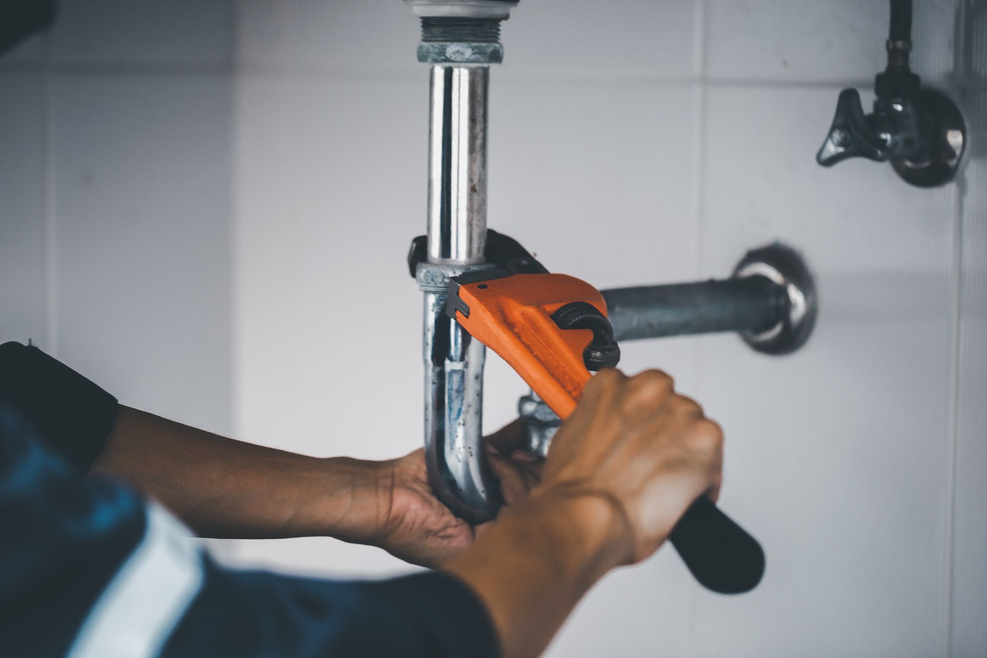 Ein Mann bohrt mit einem Hammer ein Loch in eine Ziegelwand.