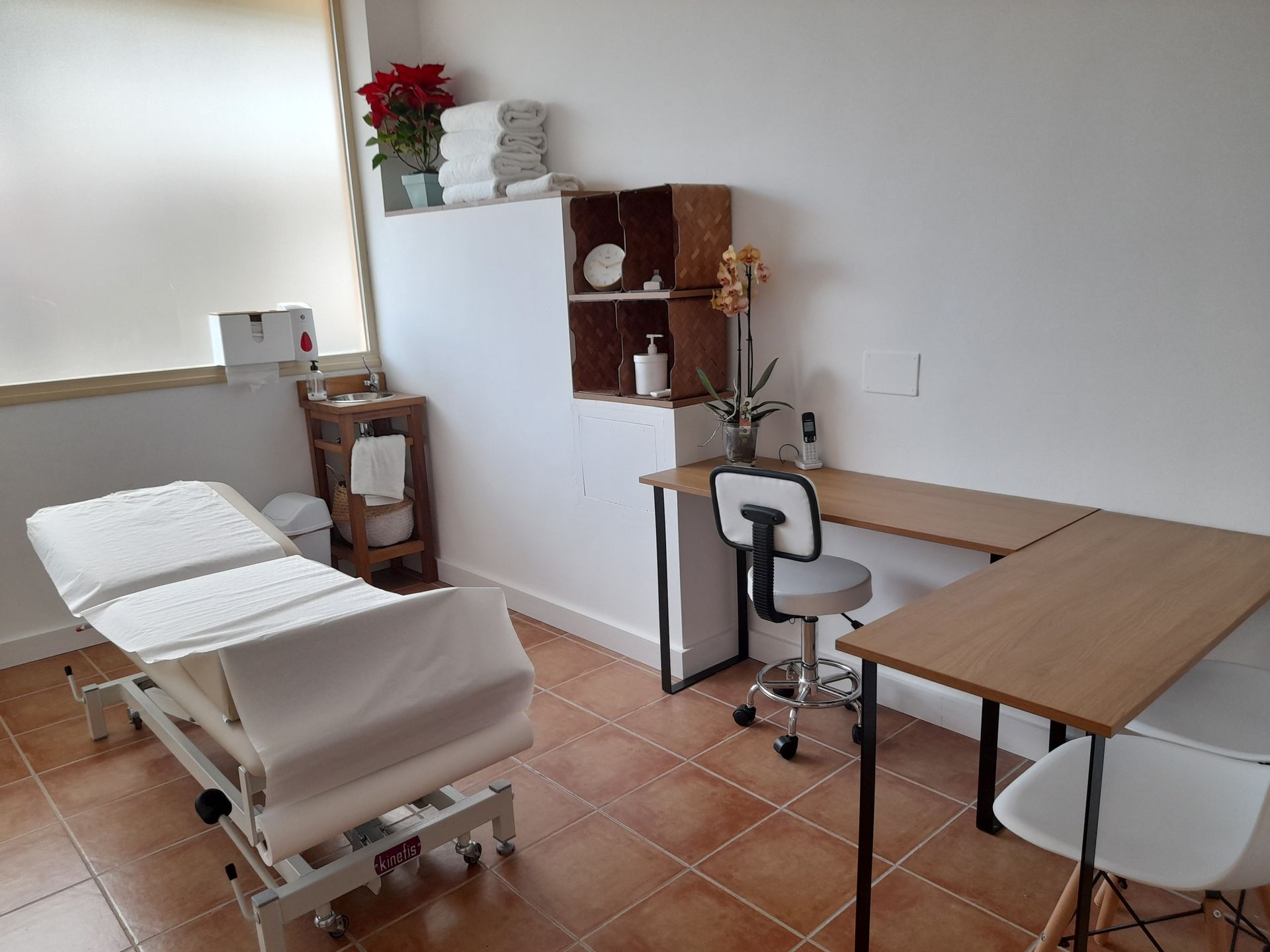 Una habitación con una cama, escritorio, sillas y una ventana.
