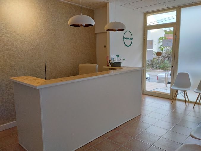 Un mostrador de recepción blanco en una sala de espera con sillas.