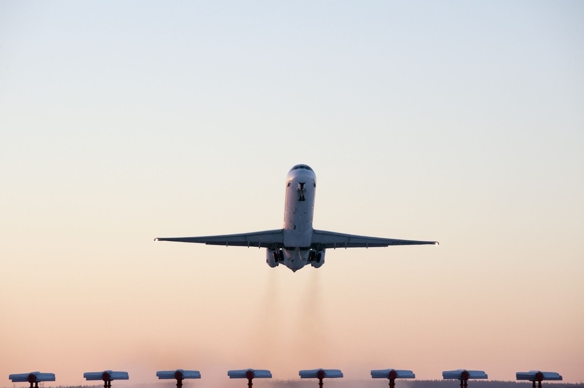 Un gran avión de pasajeros está despegando de la pista de un aeropuerto.