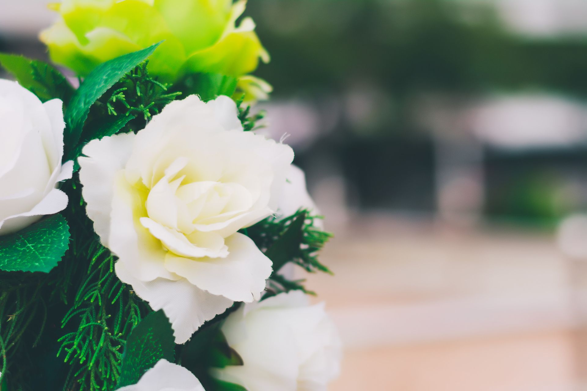 Un primer plano de un ramo de flores blancas y verdes sobre una mesa.